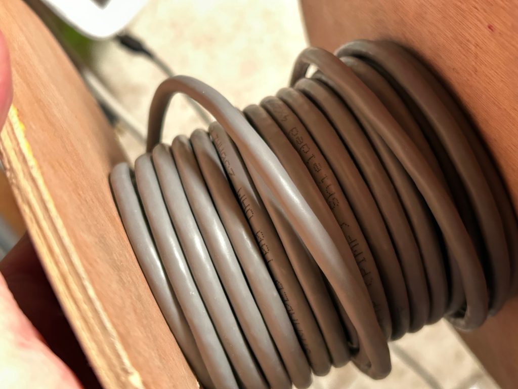 Graues Netzwerkkabel auf Rolle aus Holz
